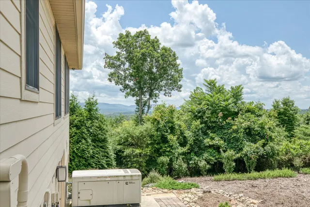 an aerial view of residential house with outdoor space and trees all around