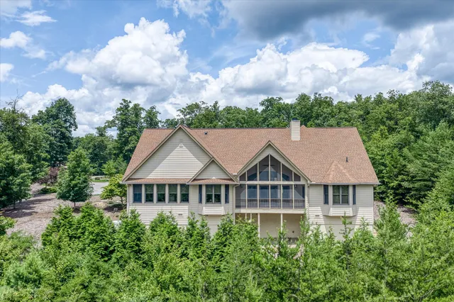 an aerial view of a house with a yard and trees