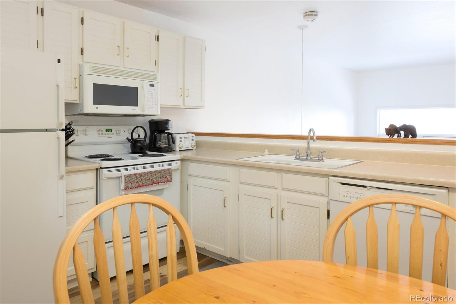 10000 Ryan Gulch Road, Unit 105 Silverthorne, CO 80498 - Photo 10 of 40 a kitchen with a sink a stove a microwave a washer and dryer