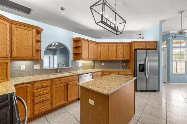 a kitchen with stainless steel appliances granite countertop a sink and refrigerator
