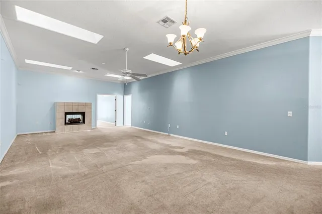 a view of an empty room with a chandelier fan