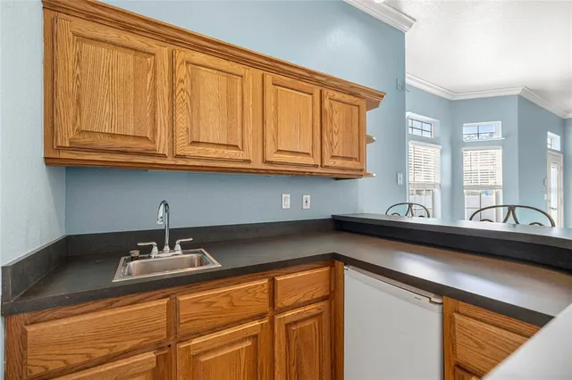a kitchen with granite countertop cabinets sink and window
