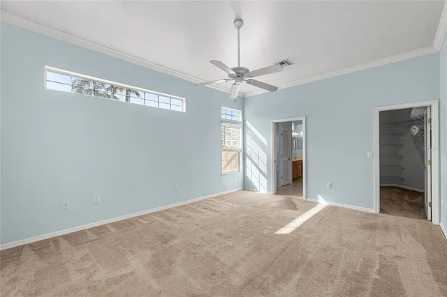 a view of a big room with chandelier fan and windows