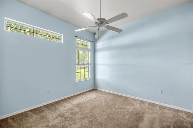 an empty room with a ceiling fan and a window