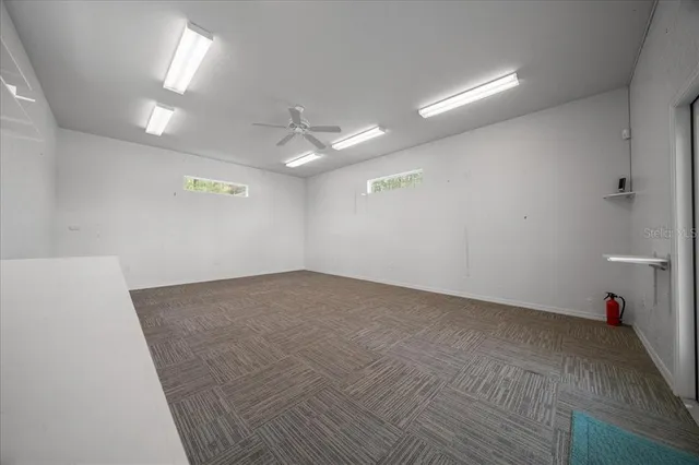 an empty room with windows and fireplace