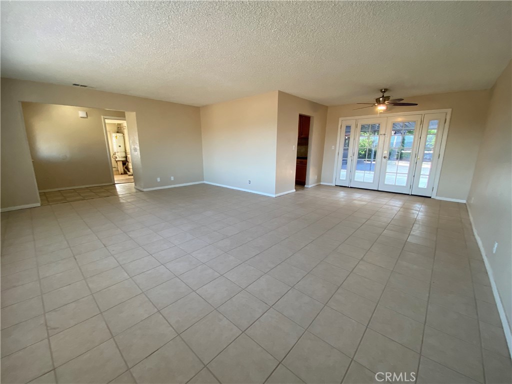 18746 Rock Springs Road Hesperia, CA 92345 - Photo 2 of 21 an empty room with chandelier and windows
