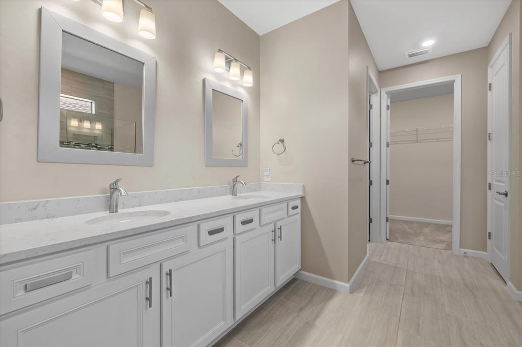 6835 Chester Trail Bradenton, FL 34202 - Photo 24 of 40 a spacious bathroom with a double vanity sink and mirror