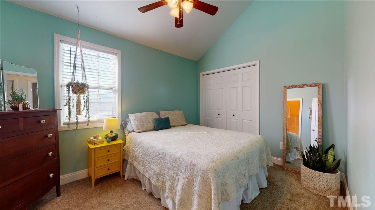 910 East Jones Street Raleigh, NC 27601 - Photo 12 of 23 a bedroom with a bed and a chandelier
