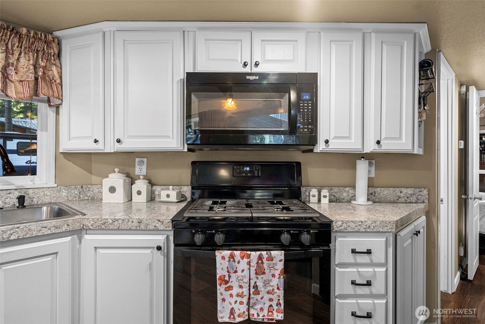 1546 Reservation Road Southeast, Unit 218 Olympia, WA 98513 - Photo 9 of 40 a kitchen with stainless steel appliances granite countertop a stove and a microwave