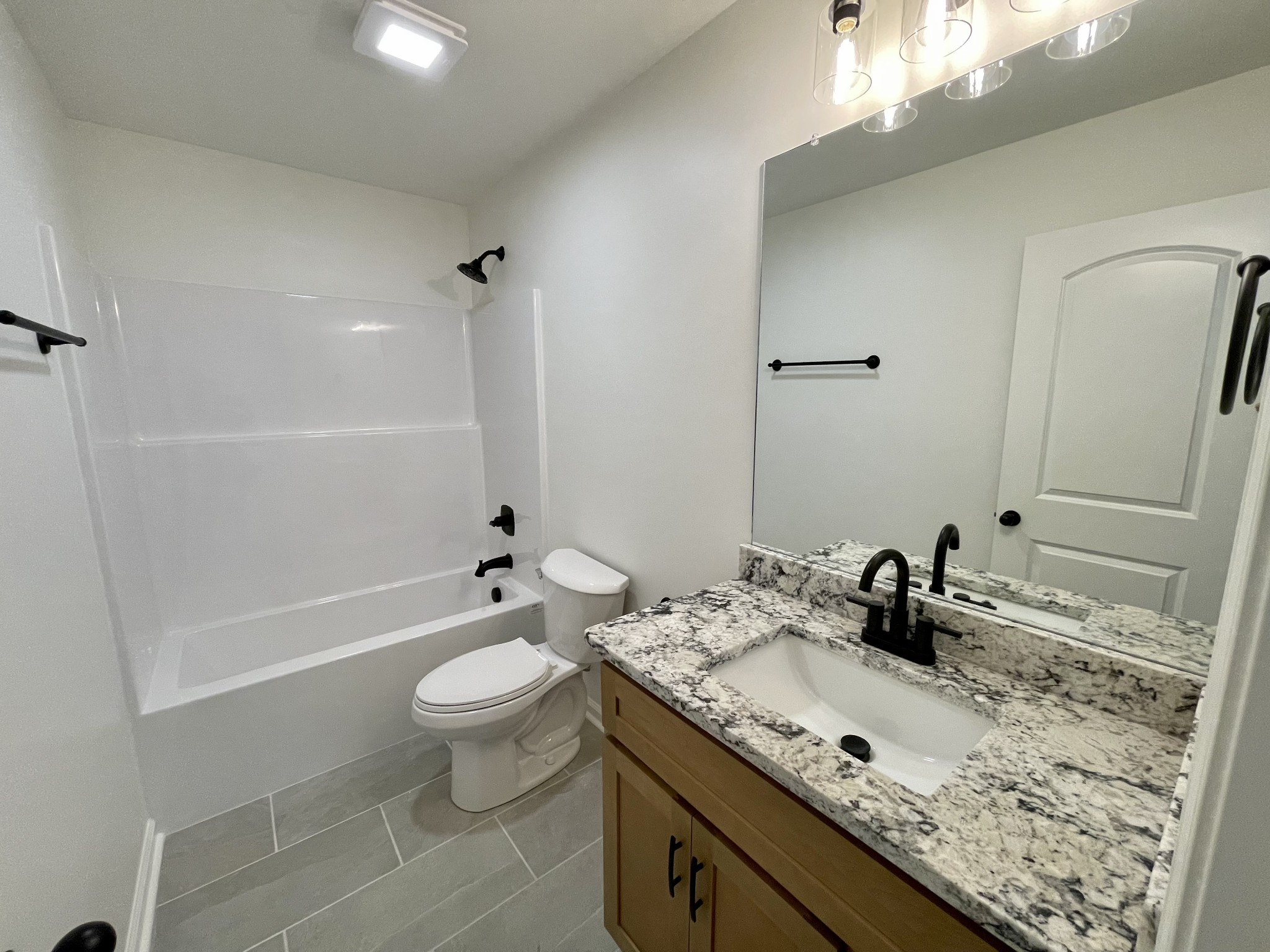 104 Donald Road Lafayette, TN 37083 - Photo 20 of 22 a bathroom with a granite countertop sink a toilet and shower