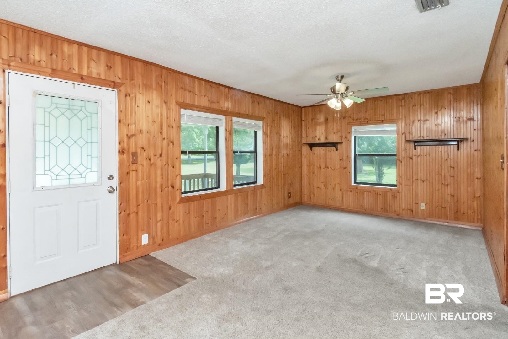 12751 Zanzibar Road Grand Bay, AL 36541 - Photo 6 of 30 Entryway with carpet flooring, a healthy amount of sunlight, ceiling fan, and wooden walls