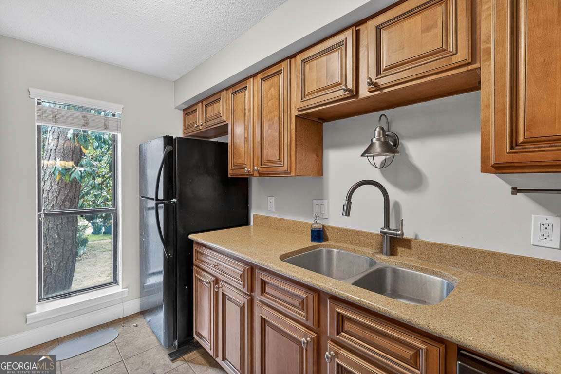 2514 Demere Road, Unit 7 St. Simons, GA 31522 - Photo 16 of 22 a kitchen with stainless steel appliances granite countertop a refrigerator and a sink