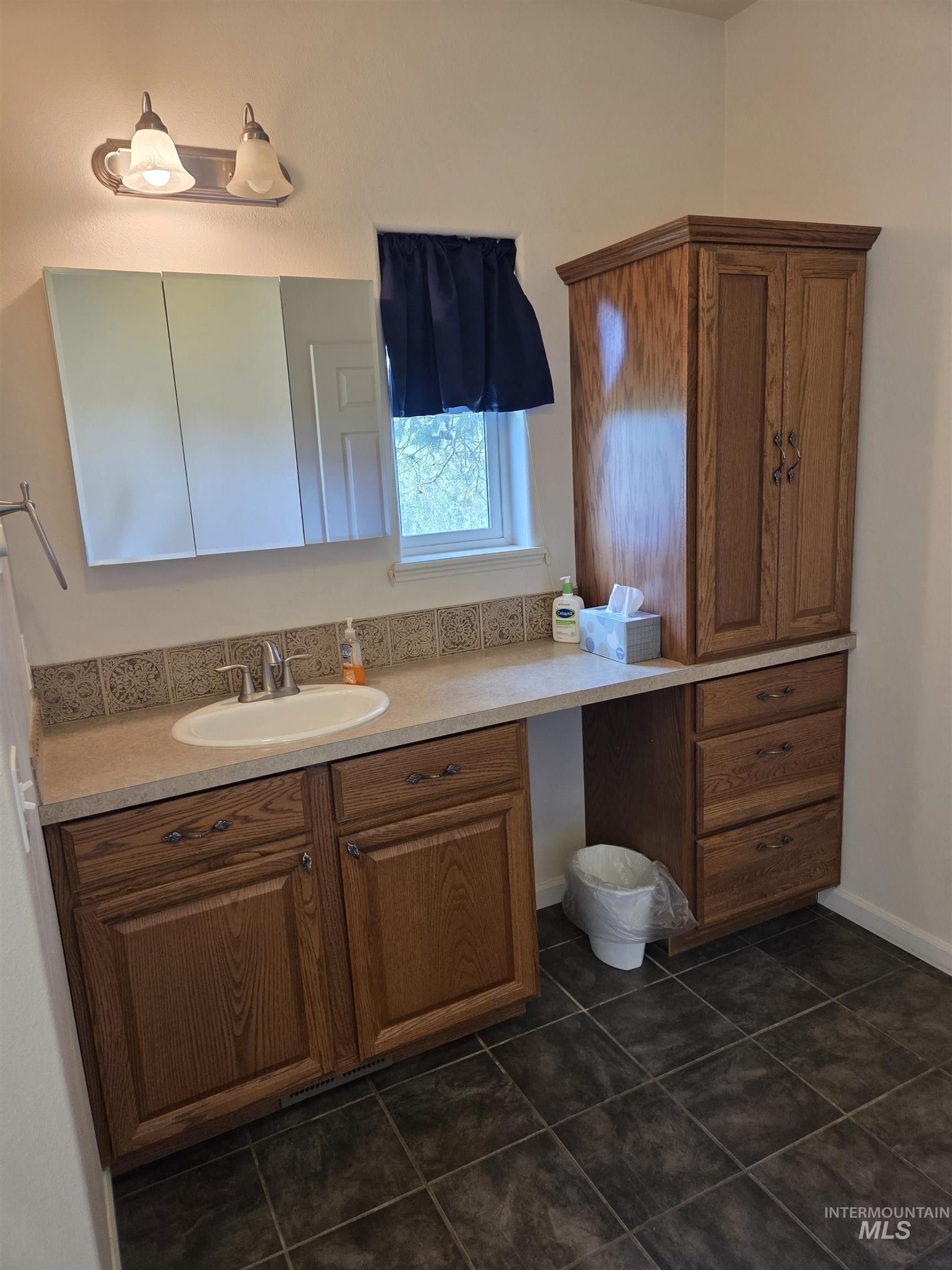1085 Wallen Road Moscow, ID 83843 - Photo 25 of 50 Bathroom featuring a wood-finish vanity with an integrated sink and laminate countertop