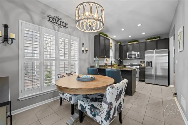 a kitchen with stainless steel appliances granite countertop a sink a stove a kitchen island with chairs and cabinets