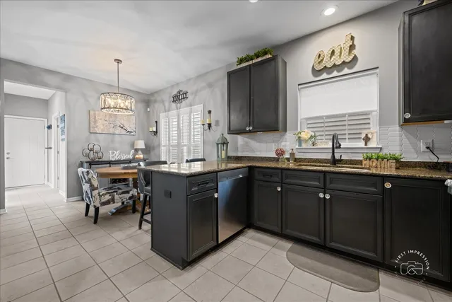 a kitchen with granite countertop a sink cabinets and stainless steel appliances