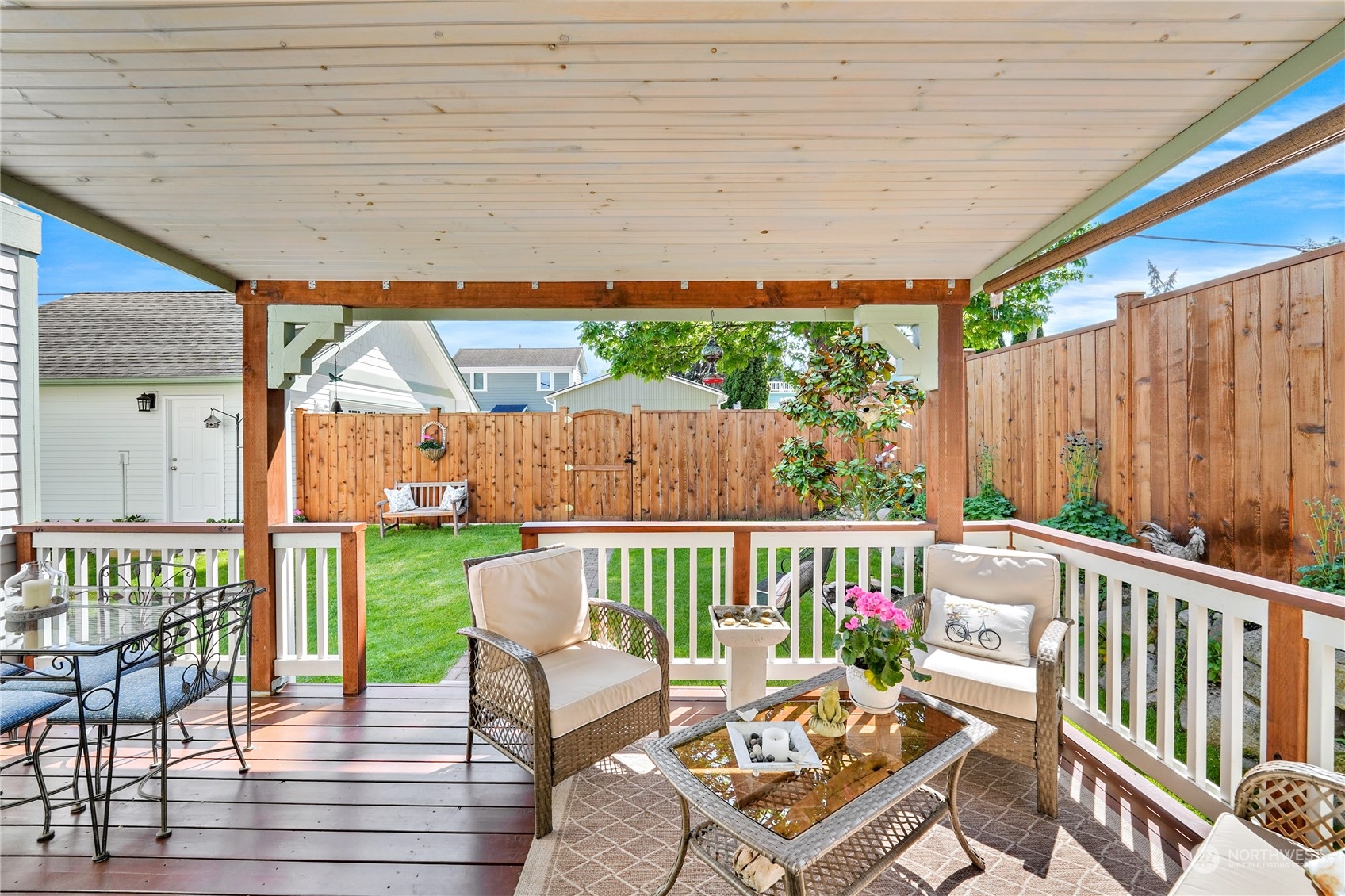 1505 9th Street Anacortes, WA 98221 - Photo 32 of 40 a patio with wooden floor a yard a table and chairs