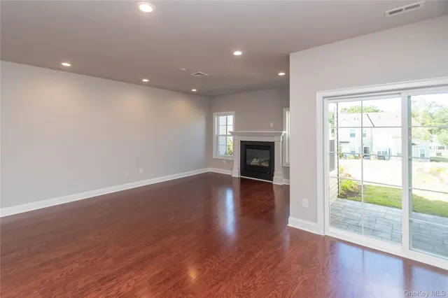 a view of empty room with wooden floor and fireplace