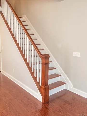 a view of staircase with wooden floor and white walls