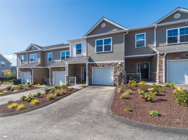 a front view of a house with a yard and outdoor seating