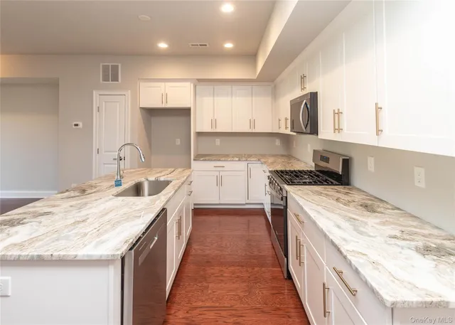 a kitchen with a stove sink and cabinets