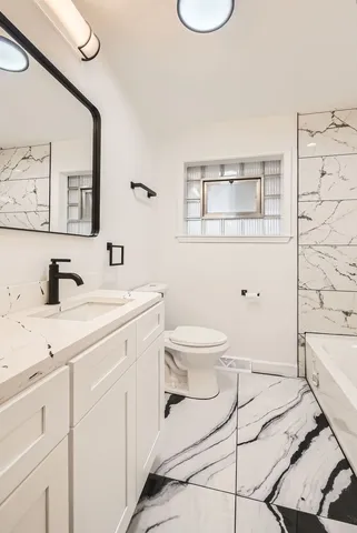 a spacious bathroom with a toilet sink and mirror