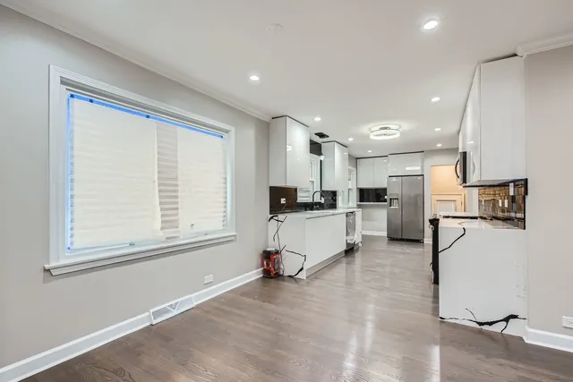 a kitchen with a refrigerator and white cabinets
