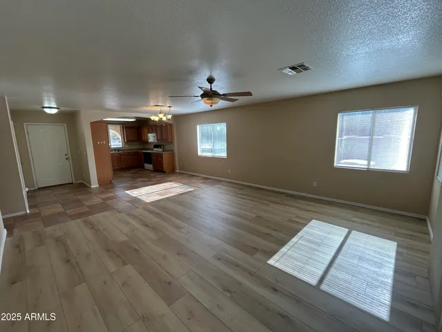 an empty room with windows and fireplace