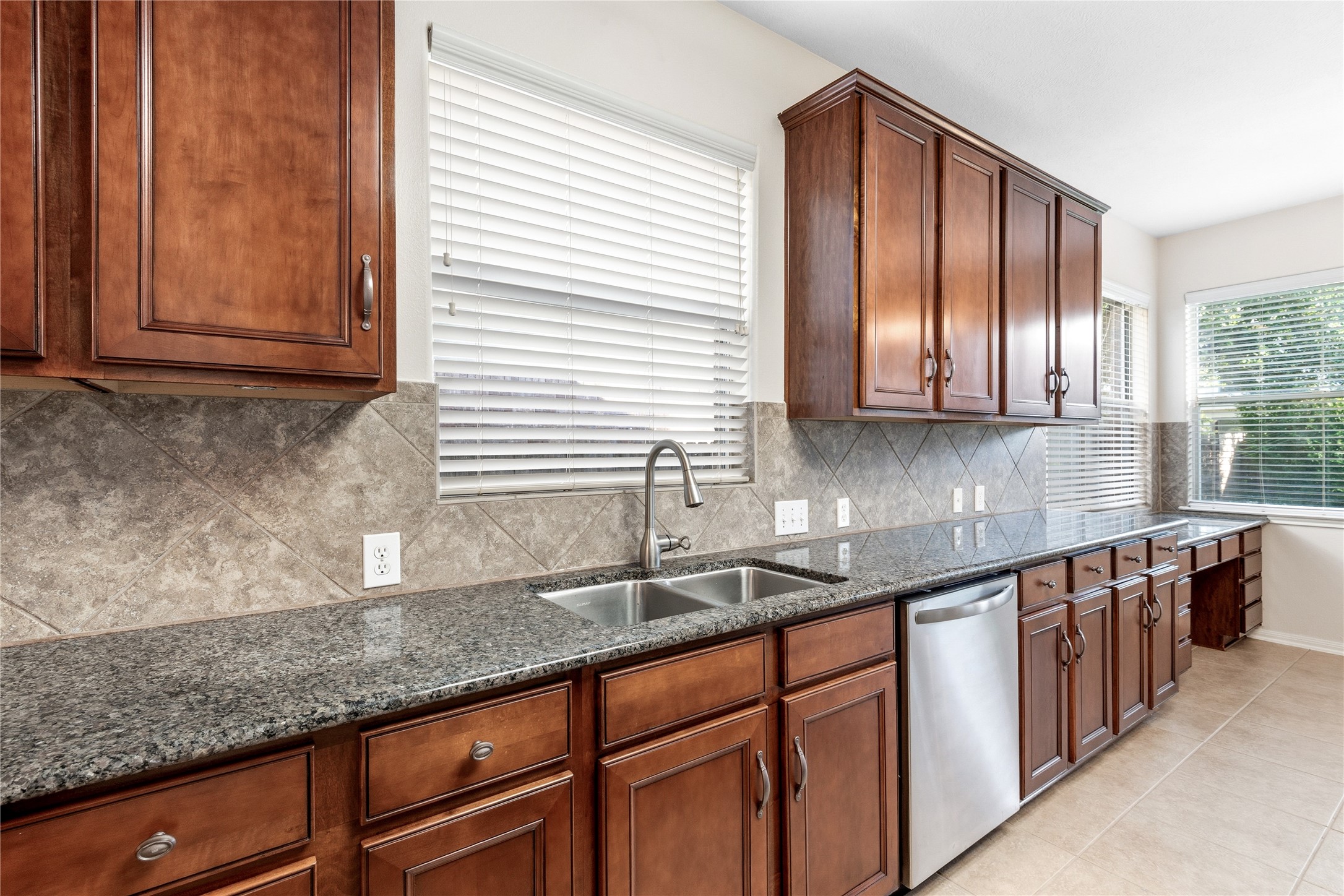 6211 Stone Hill Road Spring, TX 77389 - Photo 15 of 43 a kitchen with stainless steel appliances granite countertop wooden cabinets a sink and dishwasher next to a window