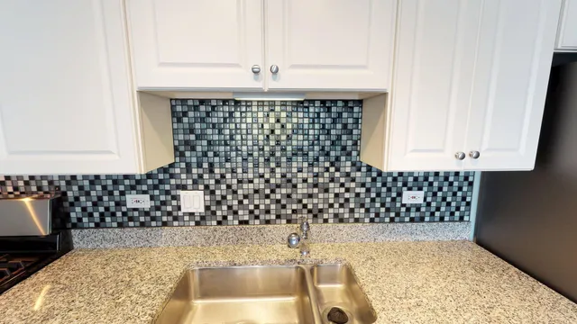 a kitchen with granite countertop a refrigerator and a stove top oven