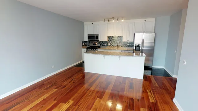a kitchen with granite countertop a refrigerator and a stove top oven