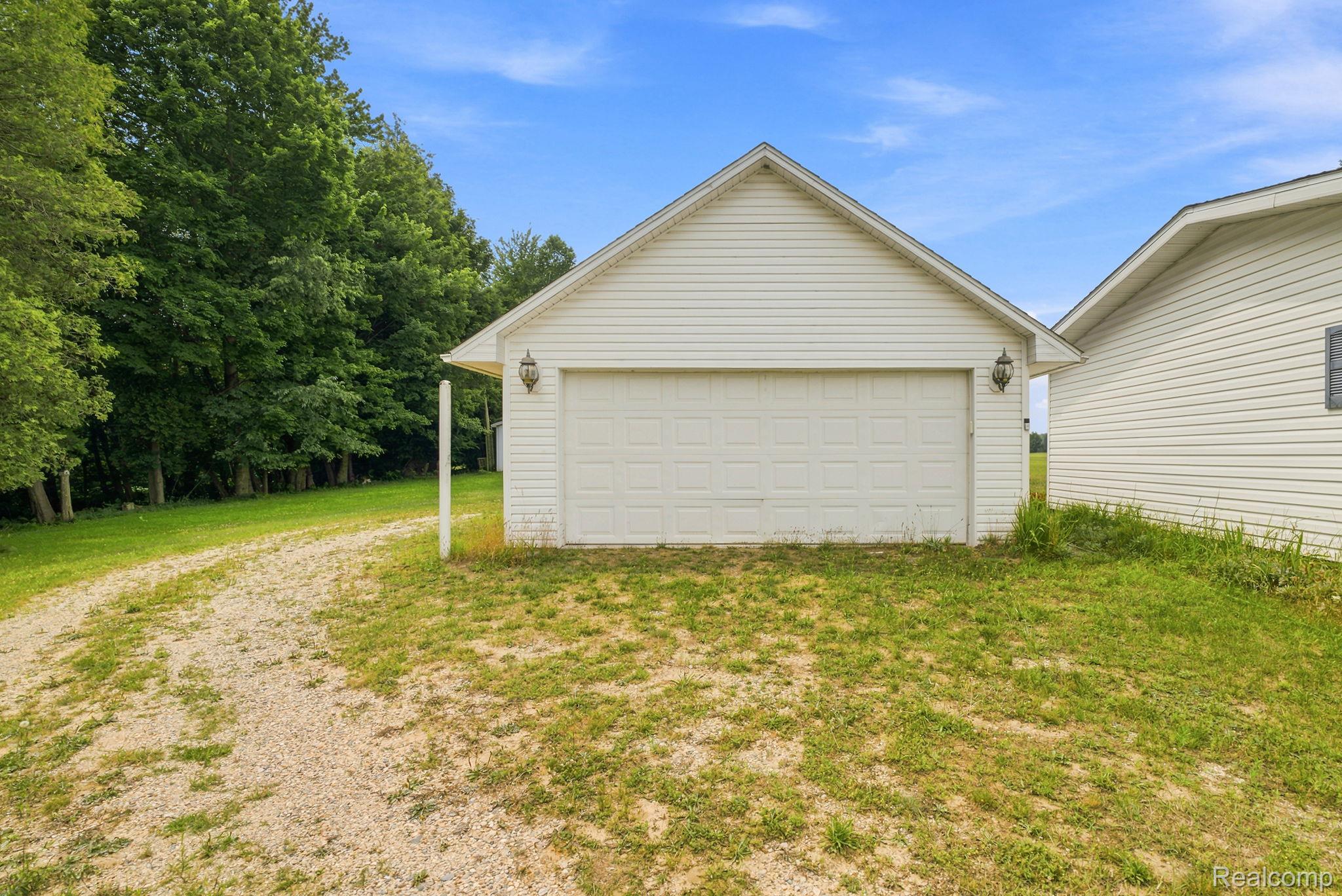 2390 Lakeshore Road Applegate, MI 48401 - Photo 30 of 97 Detached garage with neutral siding and gabled roofline, situated on a spacious lot with mature tree line and natural landscaping