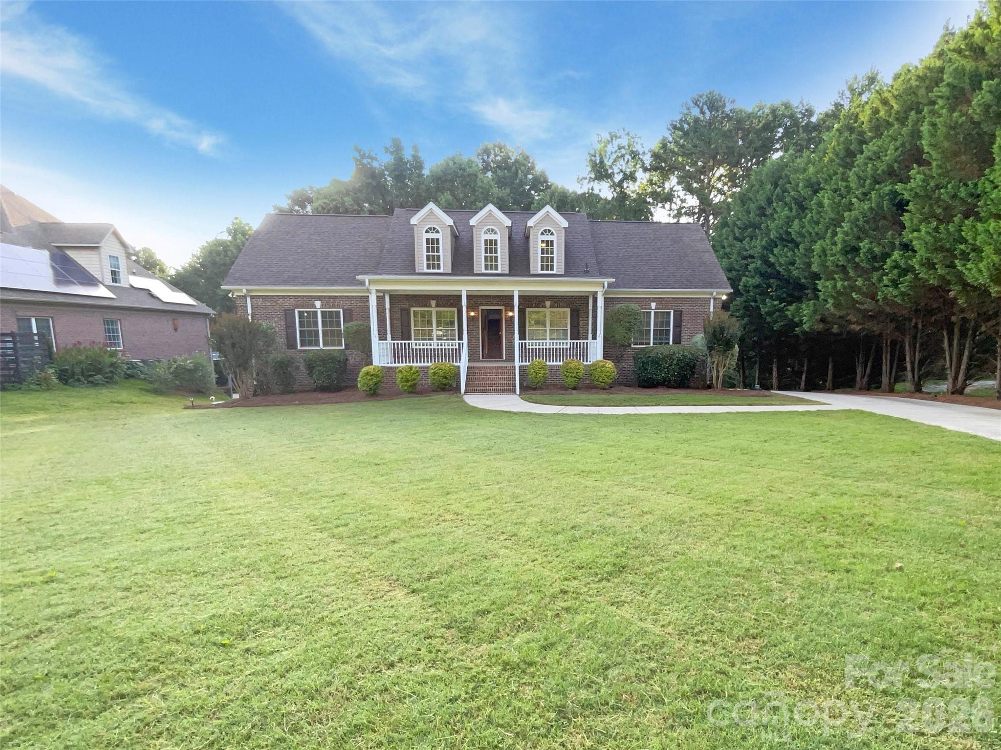 a view of a house with a big yard and palm trees