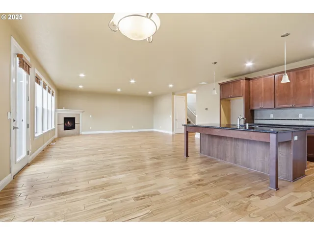 a view of kitchen with kitchen island microwave and wooden floor