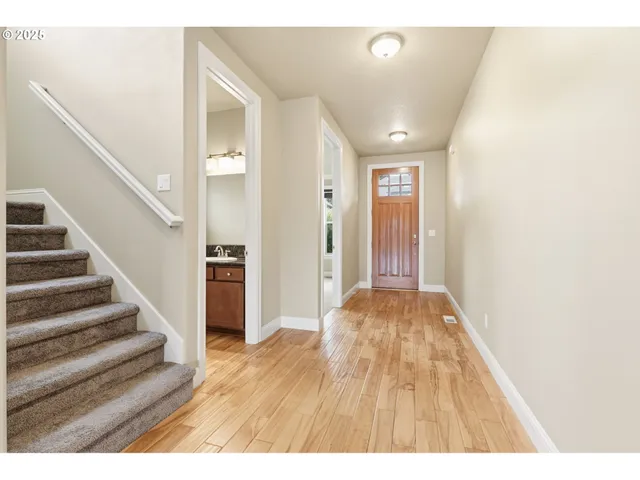 a view of a hallway with wooden floor and staircase