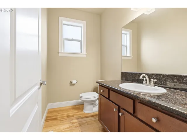 a bathroom with a granite countertop sink toilet and a mirror