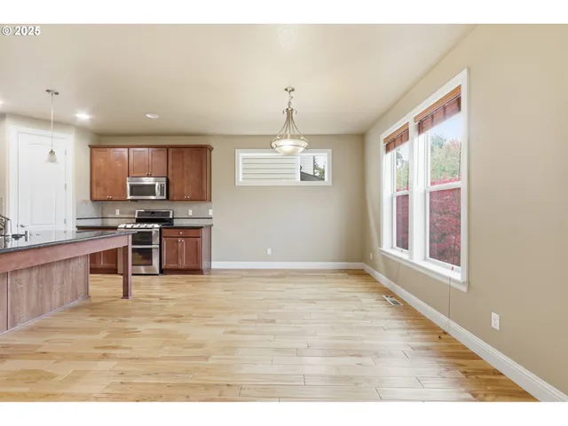 a kitchen with stainless steel appliances granite countertop a stove a sink and a microwave