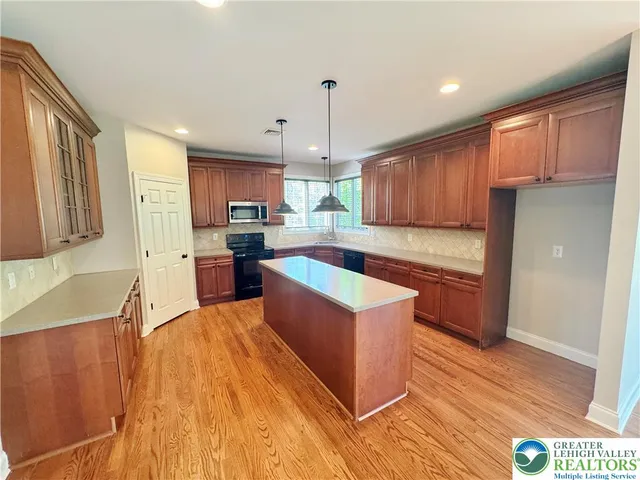 a large kitchen with stainless steel appliances wooden floors and wooden cabinets