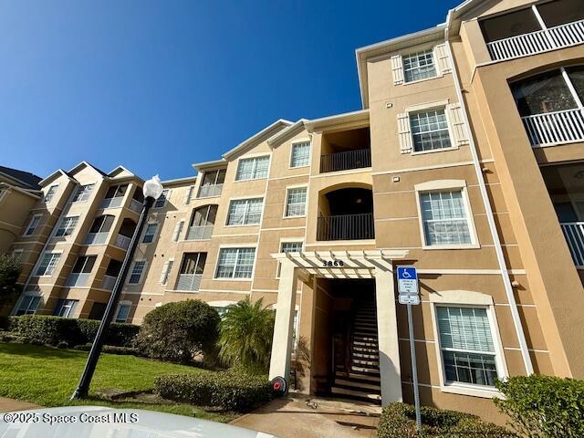 3868 Lexmark Lane, Unit 309 Rockledge, FL 32955 - Photo 28 of 40 a front view of a residential apartment building with a yard