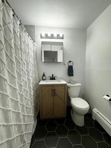 a bathroom with a granite countertop toilet a sink and mirror