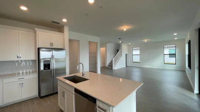 a kitchen with stainless steel appliances granite countertop a sink a stove and refrigerator