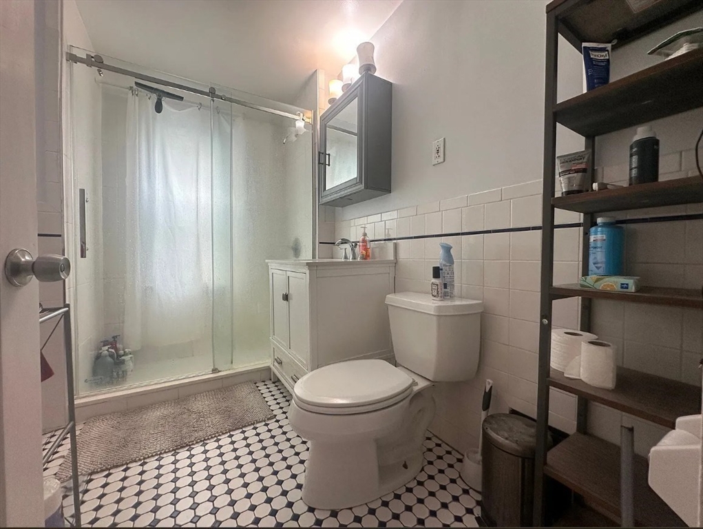 62 Bromfield Road, Unit 2 Somerville, MA 02144 - Photo 13 of 14 a bathroom with a toilet a sink and a shower