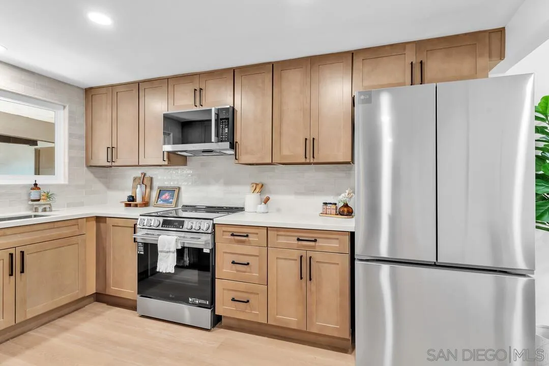 4095 Bonita Road, Unit 218 Bonita, CA 91902 - Photo 5 of 33 a kitchen with stainless steel appliances granite countertop a refrigerator stove a sink and a microwave