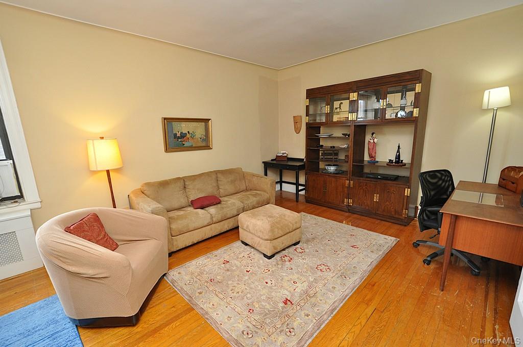 143 Garth Road, Unit 5J Scarsdale, NY 10583 - Photo 6 of 47 a living room with furniture and a flat screen tv