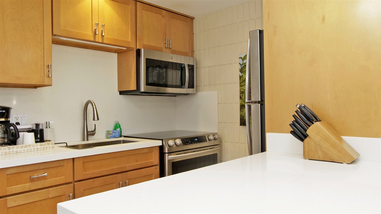 475 Front Street, Unit 624 Lahaina, HI 96761 - Photo 6 of 17 a kitchen with stainless steel appliances a stove a microwave and white cabinets