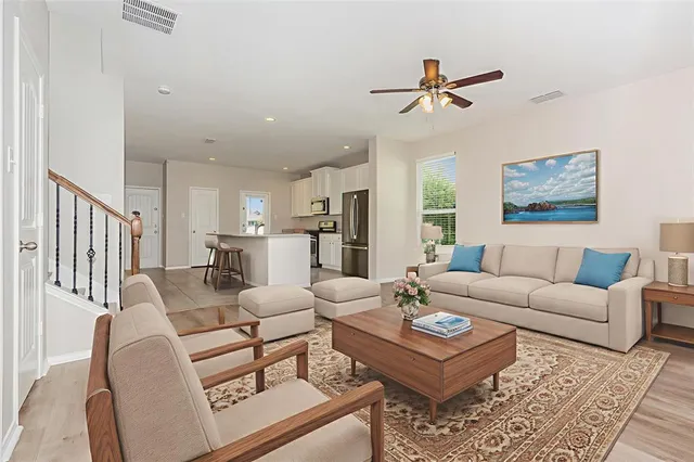 a living room with furniture kitchen view and a window