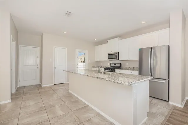 a kitchen with stainless steel appliances granite countertop a refrigerator sink and cabinets