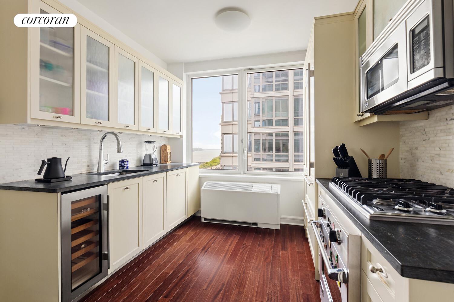 80 Riverside Boulevard, Unit 26C Manhattan, NY 10069 - Photo 3 of 6 a kitchen with stainless steel appliances a stove a sink and cabinets