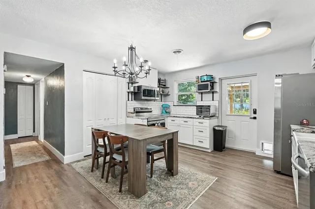 a kitchen with a table chairs refrigerator and microwave