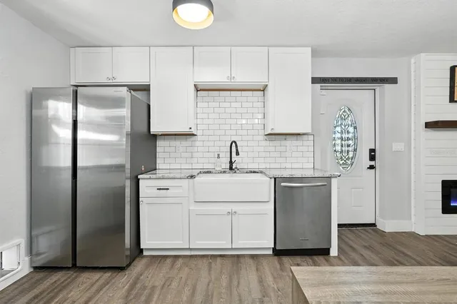 a kitchen with stainless steel appliances a refrigerator sink and cabinets
