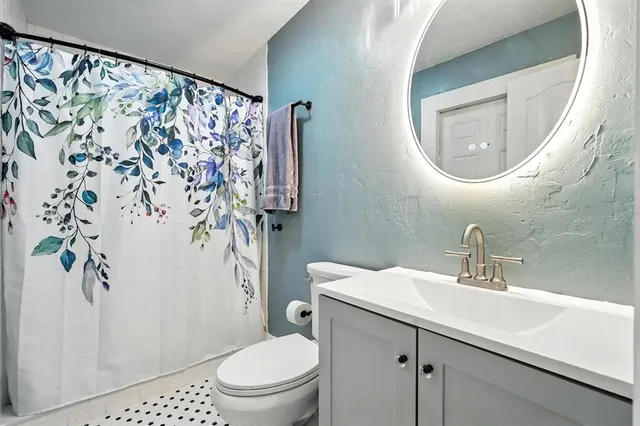 a bathroom with a toilet sink and mirror